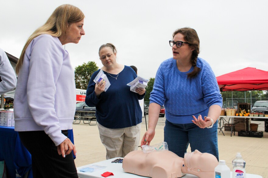 Robyn Grinzinger, working for Nimkee Memorial Wellness Center, gives Mount Pleasant community members Elizabeth Armstrong and Melissa York a CPR demonstration during the national Save a Life day event held at Island Park in Mount Pleasant, Michigan on Thursday, September 25, 2025.