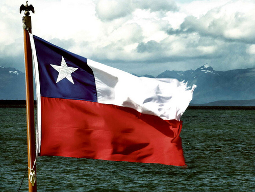 Flag of Chile waves in front of a windy sea