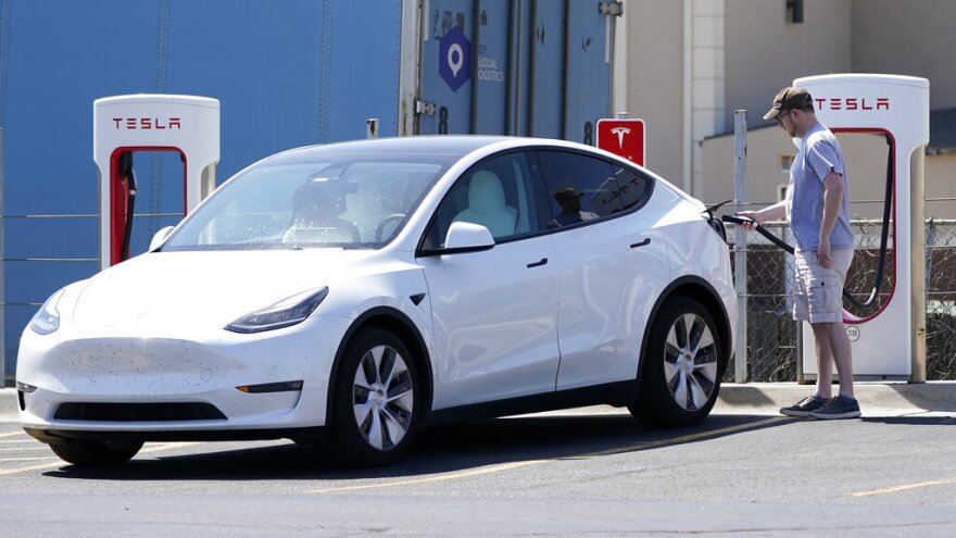 A Tesla owner charges his vehicle in April 2021 at a charging station in Topeka, Kan.. Tesla reported 273 crashes involving partially automated driving systems, according to statistics released by U.S. safety regulators on Wednesday.