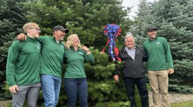 Members of the Korson family standing in front of the winning tree with White House Grounds Superintendent Dale Haney (center).