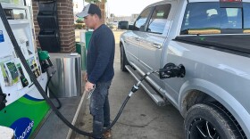 Josue Hernandez, 35, pumps gas into his work pickup truck.