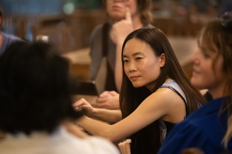 Rachel Cheong, a participant of The New Yorker Weekly Short Story Club, listens as the group discusses the story of the week during a meeting at Central Market on Tuesday, Aug. 26, 2025. Lorianne Willett/KUT News