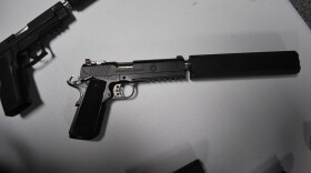 A .45 cailber sound supressor attached to a handgun.