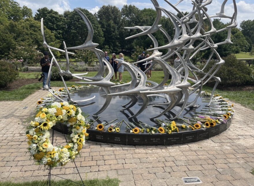 Well-wishers surrounded the Comair Flight 5191 memorial statue with flowers Aug. 27, 2026, commemorating the 49 lives lost in the crash 20 years prior.