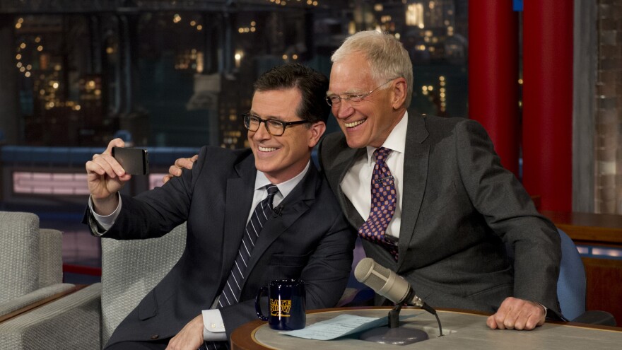 David Letterman, seen here snapping a selfie with his replacement Stephen Colbert, will step down next week as host of the <em>Late Show.</em>