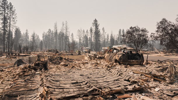 Dozens of houses are seen destroyed in a residential neighborhood as crews begin to check the area after a wildfire hit the northern part of Spokane, Wash., Tuesday, Aug. 4, 2026. (AP Photo/Lindsey Wasson)