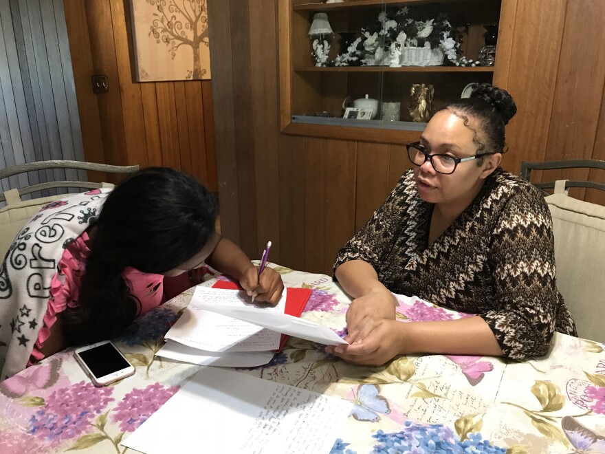 Wanda Kemp helps her daughter, Za’Riah, with homework. 