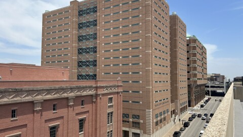  A photo of three red brick buildings in downtown Fort Worth. The one in the middle is a tall, double tower with a sign that says "Tarrant County Correction Center."