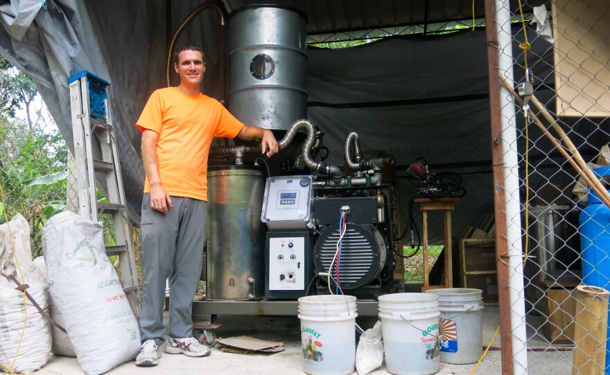 Benjamin Shell helps run the electric company in the village of Tuffet. Behind him is the generator that has given electricity to 30 families so far.