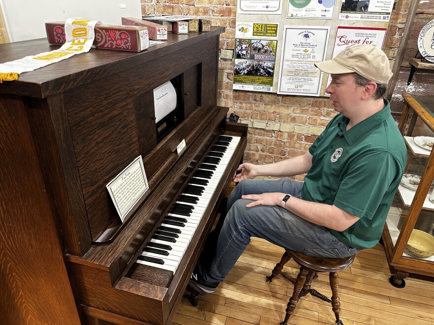 Cedarburg History Museum Director Joel Willems plays a roll of music using a 20th century player piano.