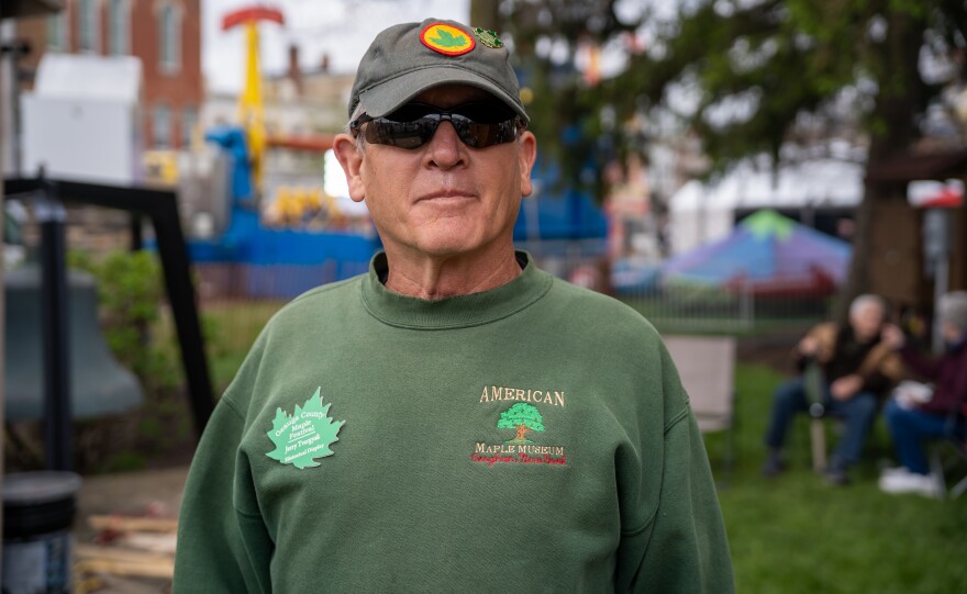 Man stands in front of festival.