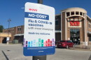 A sign offering no-cost flu and COVID vaccines with insurance at a CVS in Kansas City, Missouri.