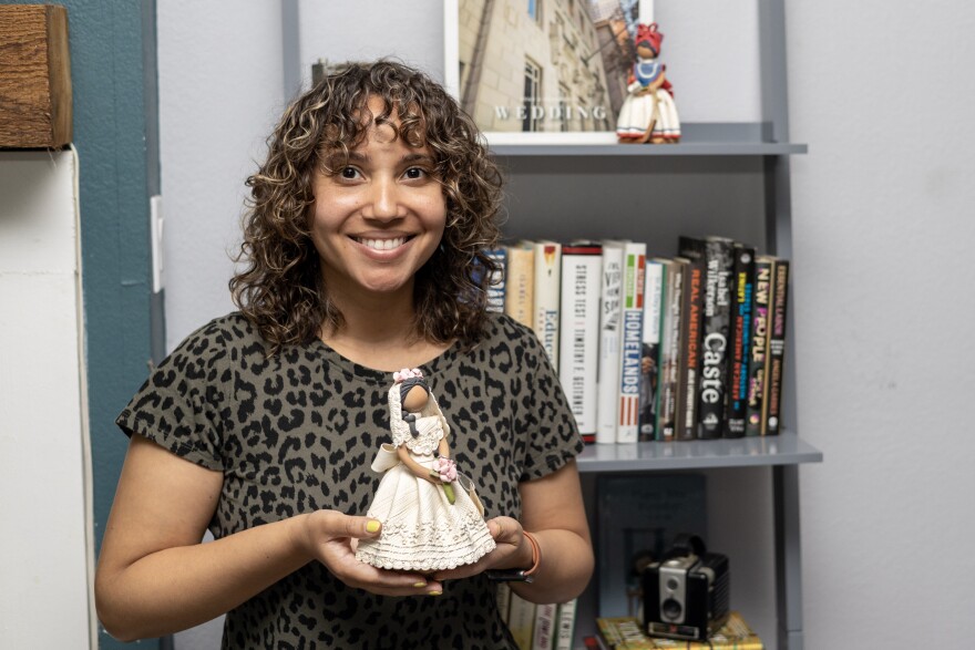 Sam Guzman holds one of her muñecas sin rostro in her Oak Cliff living room.