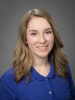 Headshot of journalist Natalie Van Hoozer in a blue shirt.