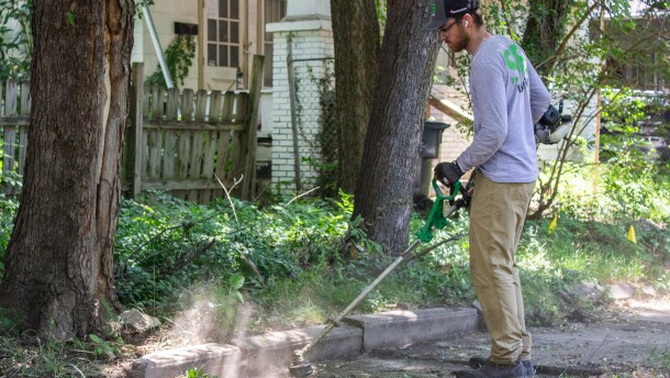 SB Mowing owner Spencer edges a sidewalk while working in a Wichita neighborhood on Friday afternoon.