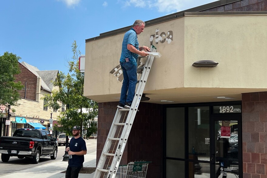 A Bank of America sign is removed from the bank's closed Roslindale branch. 