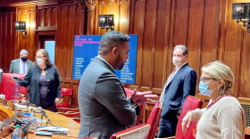 Sen. Dennis Bradley talks to Courtney Cullinan, the deputy chief of staff to the Senate Democrats, about his plans to challenge Sen. Mae Flexer, left, about the absentee voting bill.