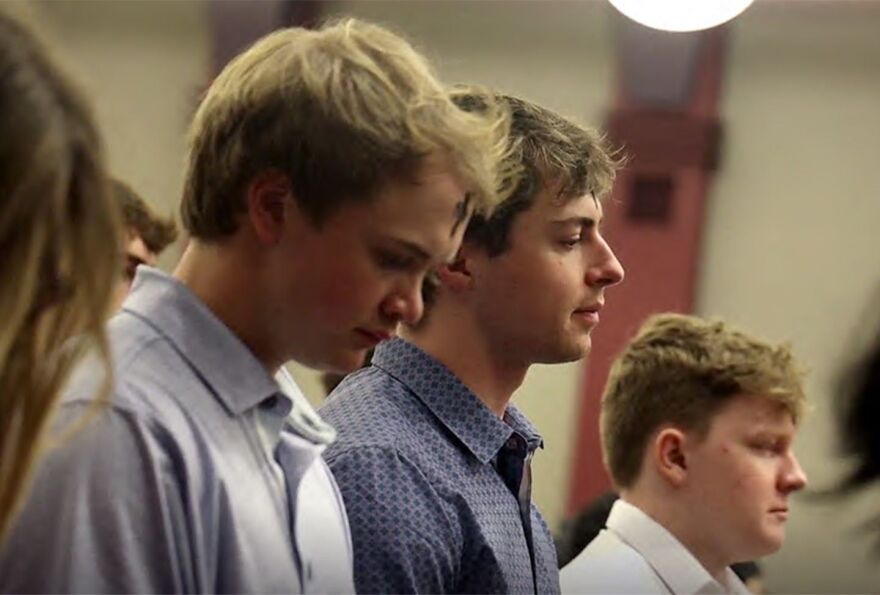 USC students bow their heads in prayer, ashes marked on their foreheads during an Ash Wednesday service.
