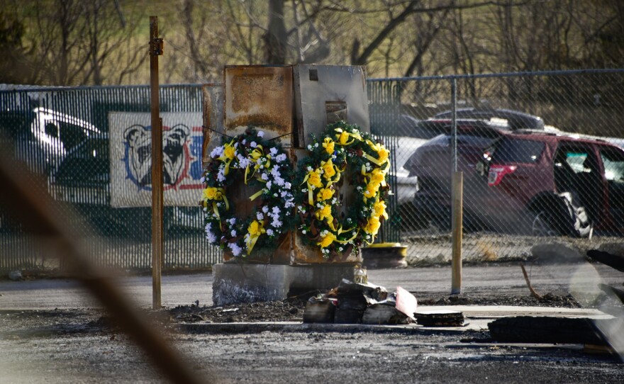 Two memorial wreaths hang on a metal structure near a junkyard where victims were found in the aftermath of the UPS plane crash.