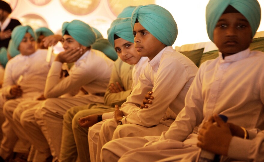 Indian and Pakistani Sikhs gather in a tent flung up near their holiest site, the Gurdwara Darbar Sahib Kartarpur, to watch Pakistan's Prime Minister Imran Khan break ground on a corridor that will link to the area to India, and allow visa-free travel for Indian Sikhs to the holy site.