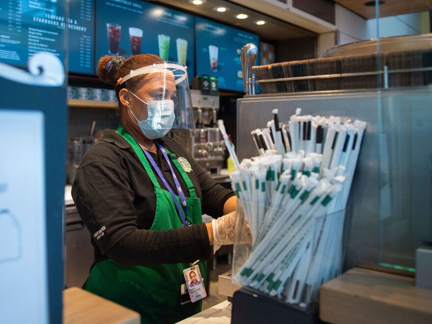 A Starbucks employee wears a face shield and mask as she makes a coffee drink at Ronald Reagan Washington National Airport in Arlington, Va., last week.