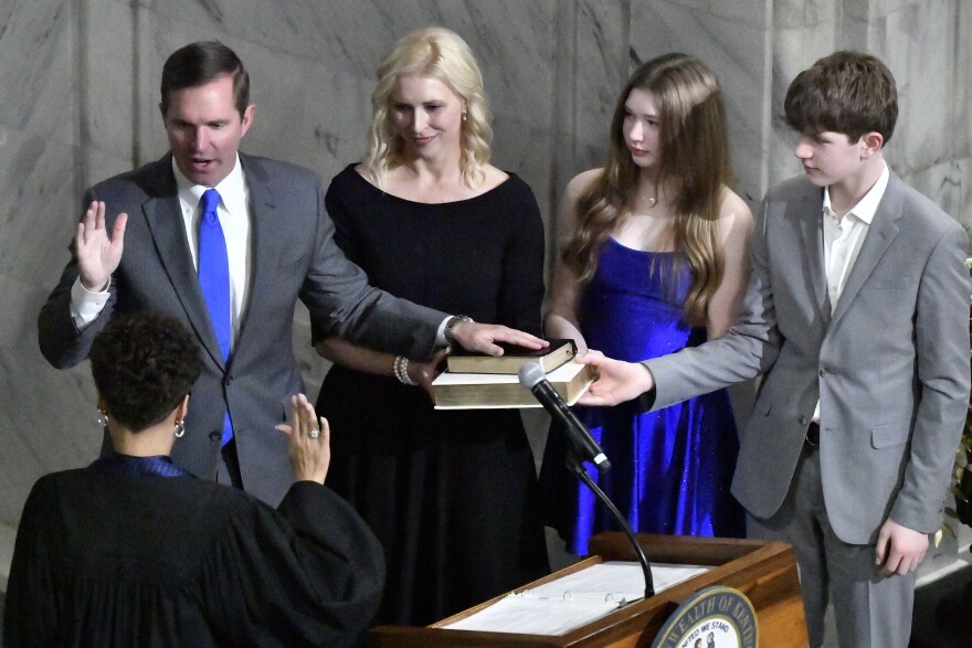 From left, Kentucky Gov. Andy Beshear, his wife, Britainy Beshear, his daughter Lila and his son Will stand by his side as he takes the oath of office from Kentucky Court of Appeals Judge Pamela Goodwine during his inauguration in Frankfort, Ky., early Tuesday, Dec. 12, 2023. (AP Photo/Timothy D. Easley)