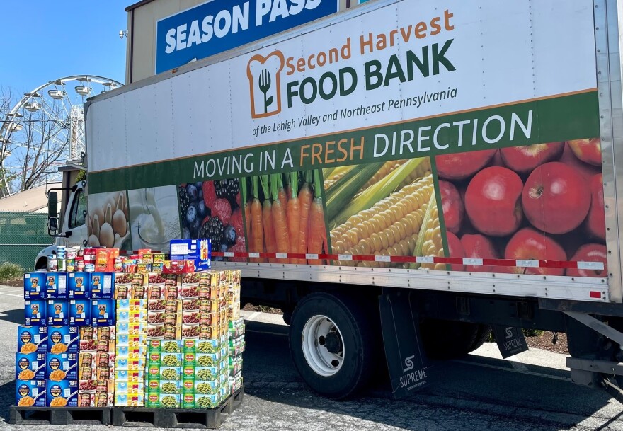 A pallet of food next to a Second Harvest truck.