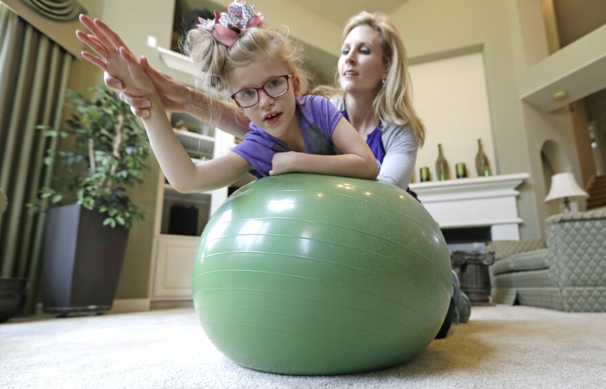 mom working on core strength on exercise ball with daughter