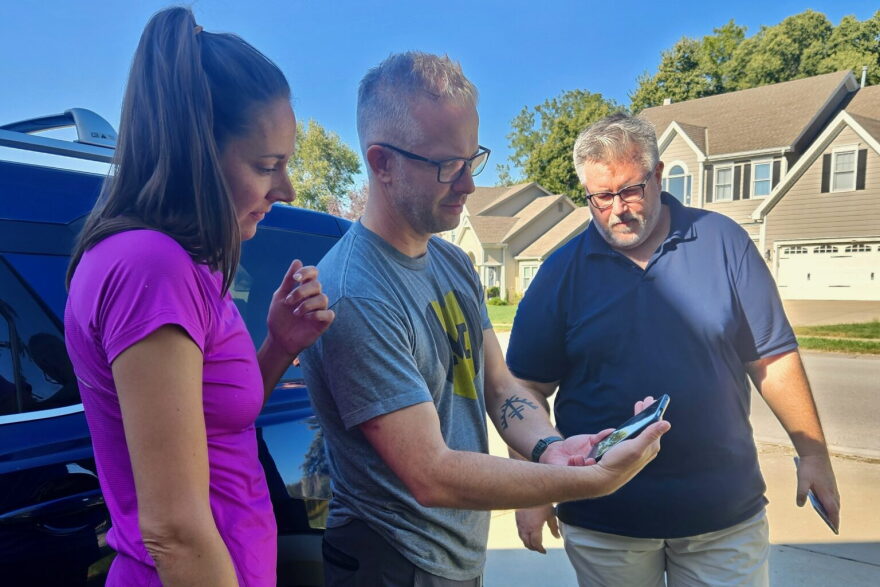 Tracey Steele, right, watches his online ad, with Matt Smithmier, center, and Jess Toms, left, while campaigning for the 12th District Missouri House seat on Oct. 10, 2026, in the Thousand Oaks neighborhood of southern Platte County. Smithmier did the voiceover work on the ad.