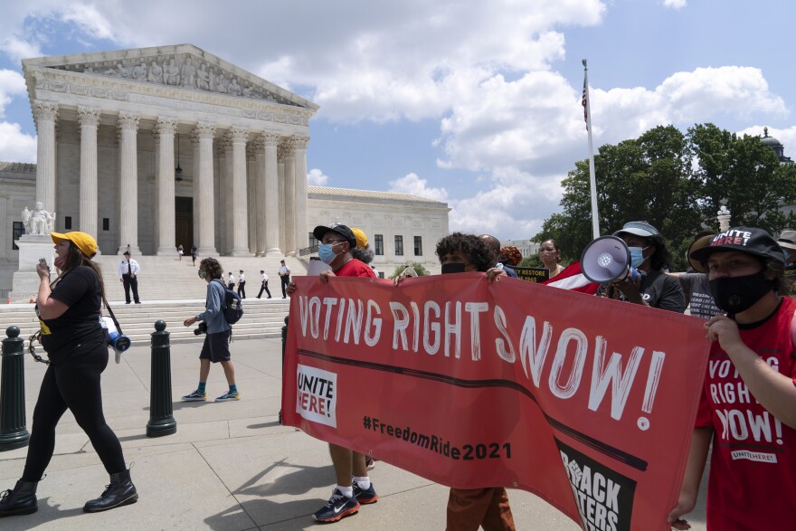 Voting rights activists march outside of the U.S. Supreme Court, during a voting rights rally on Capitol Hill, in Washington, Monday, Aug. 2, 2021.