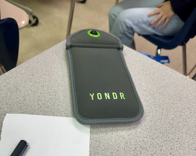 A magnetically-shut Yondr pouch sits on a student's desk. The school district bought pouches for every middle and high school student, totaling more than $300,000 this year.
