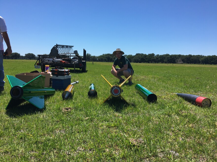 Rocket pieces laid out in a field. 