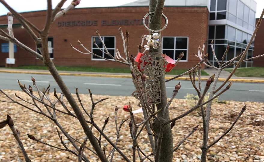 An inscribed wooden angel on the tree Yoshi's family planted at Creekside Elementary School, where she attended second grade.