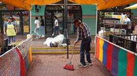 A vendor in Market Square sweeps.
