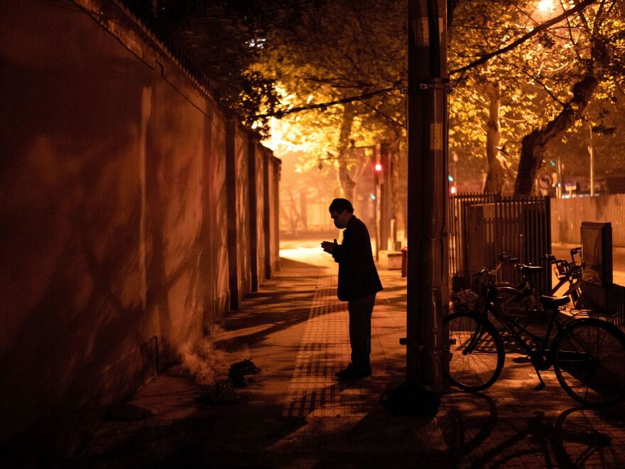 A resident of Wuhan prays after burning paper offerings during the Tomb Sweeping festival, also known as Qingming festival, on April 4, 2020, a holiday to honor ancestors. Last year, a China called for a 3-minute silence on this day to mourn patients and medical staff killed by the coronavirus.