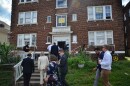 People walk into a brick apartment building