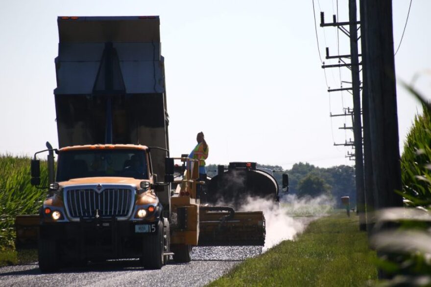 A Miami County highway crew chip-and-seals a road on July 30, 2026.