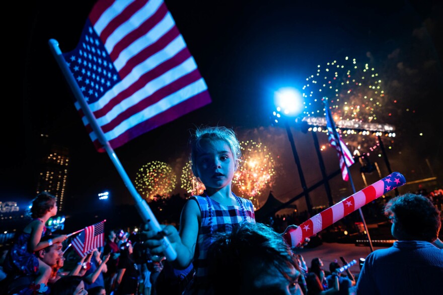 Spectators watch from the Queens borough of New York as fireworks are launched over the East River and the Empire State Building during the Macy's 4th of July Fireworks show, Sunday, July 4, 2021.