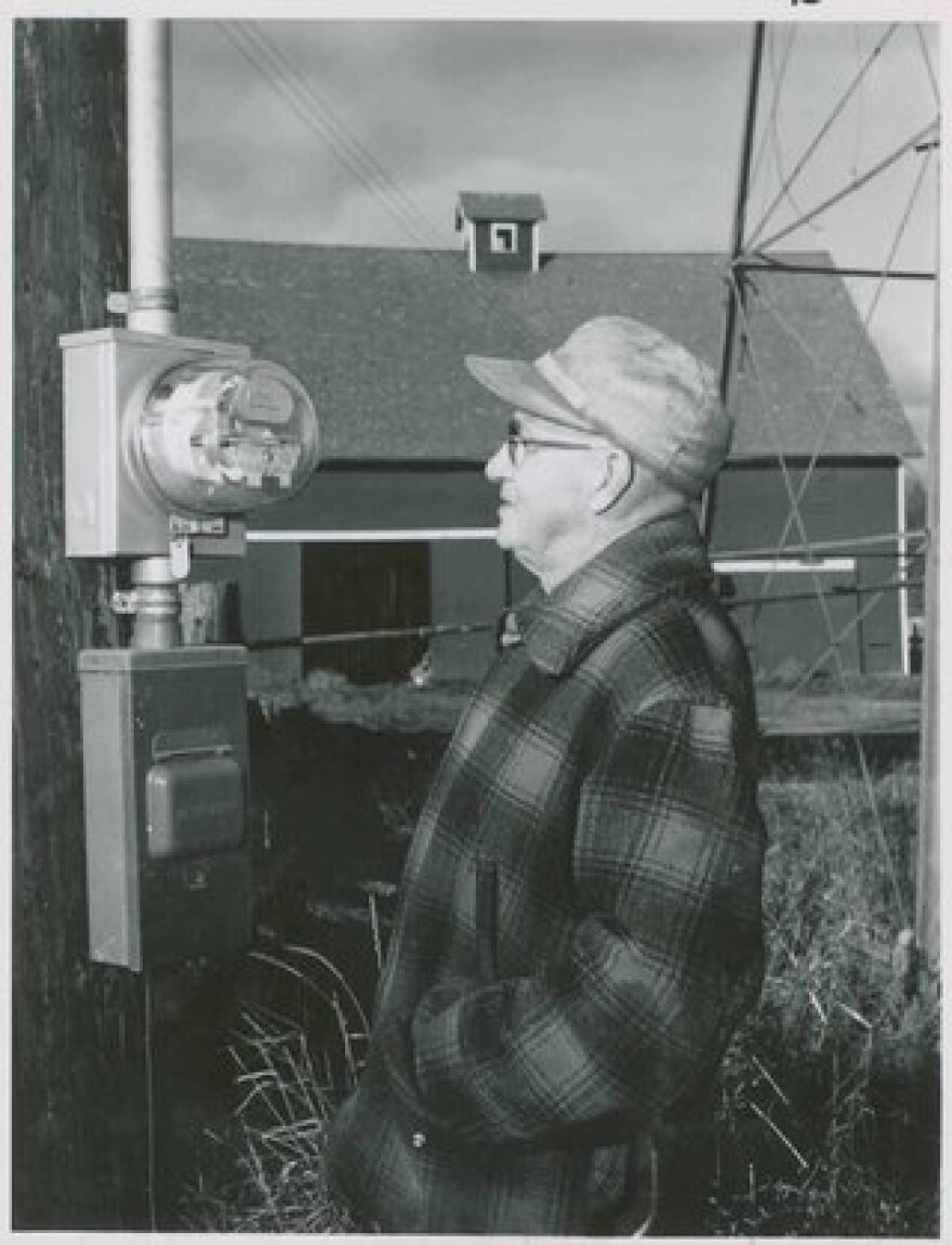 Smith Robbins looking at this new electric meter installed on his farm near Watertown, South Dakota, 1954.