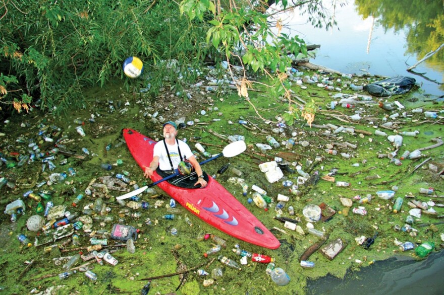 Man cleaning trash out of the Jordan River.