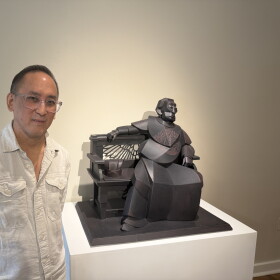 Artist Warren King stands next to his cardboard sculpture titled "The Emperor Takes Five."