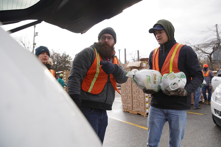 Volunteers Dominic Grifo and Jacob Bias load turkeys and other food items into a vehicle at the Greater Cleveland Food Bank's Thanksgiving food distribution on Thursday, Nov. 17, 2022.