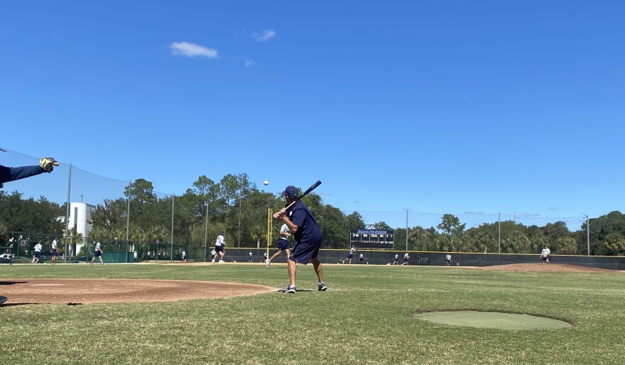 Johnny Wiggs participating in a recent Santa Fe practice. Wiggs is hitting balls to the outfield for drills. (Dylan Pierce/ WUFT News)