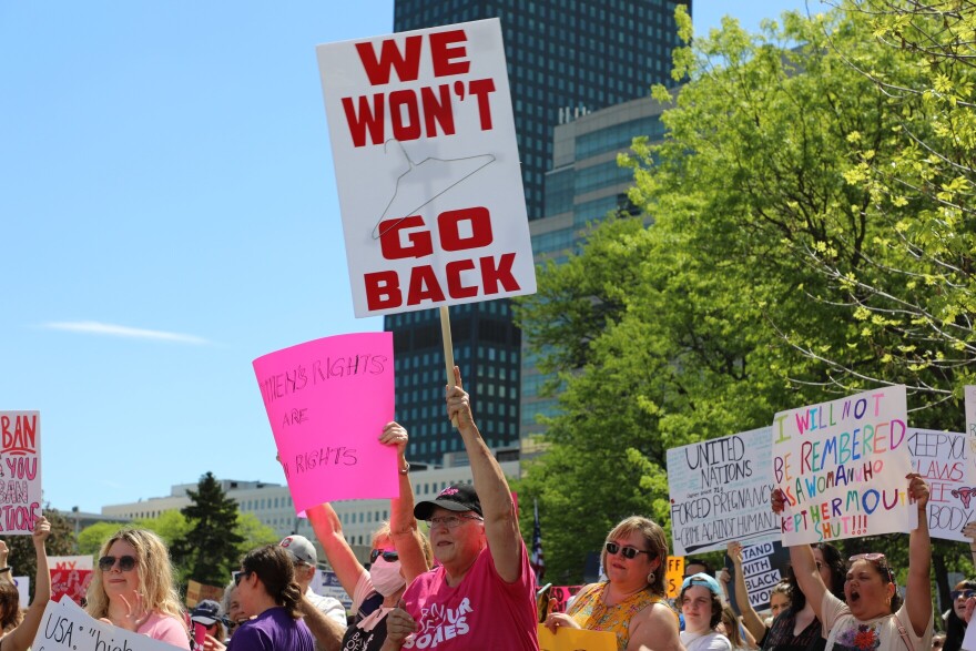 Lenore Robinson, a nurse from Wickliffe, carries a sign with a wire coat hanger, a reminder of a time when abortion was illegal.