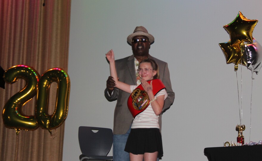 James "Buster" Douglas puts a first place boxing belt on a first place winner at the District Speech and Debate Championship at Manual Hight School.