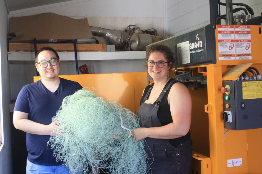 Basil Tilden and Nicole Baker in front of their compactor, which squishes fishing nets into 350 lb. bales.