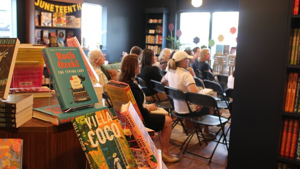 People sit in chairs during a book club gathering at the Hive Bookshop.