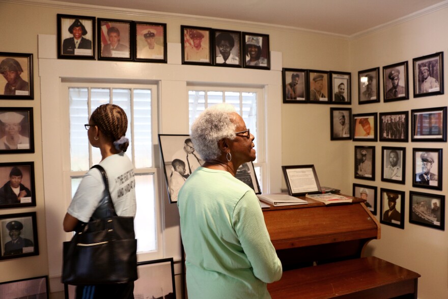 (Joy Bonala/KACU) Women browse through photographs of Taylor County African-American Service members. 