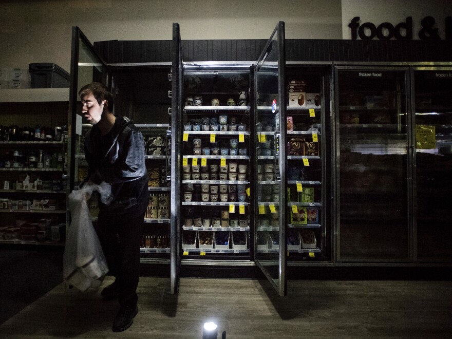 James Quinn throws out ice cream from freezers at a CVS during an intentional blackout in Sonoma, Calif., on Oct. 9.