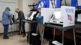 FILE - Poll workers set up ballot-marking machines at an early in-person voting site at Asheville-Buncombe Technical Community College, Wednesday, Oct. 16, 2024, in Marshall, N.C.